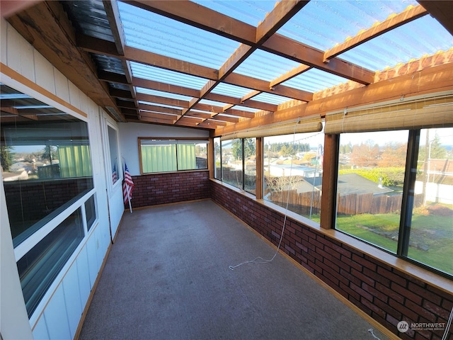 unfurnished sunroom with beam ceiling and plenty of natural light