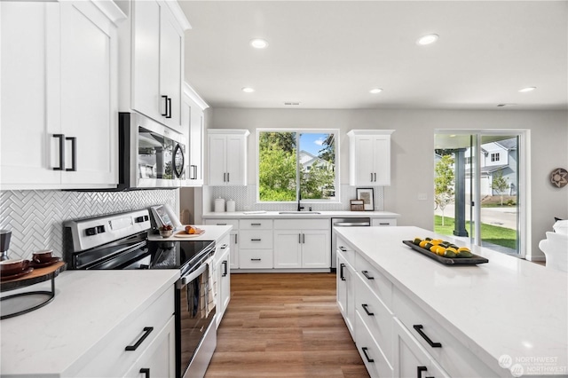 15507 65th Avenue Ct E, Puyallup, WA 98375 - kitchen with stainless steel appliances, light countertops, backsplash, white cabinets, and recessed lighting