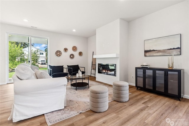 15507 65th Avenue Ct E, Puyallup, WA 98375 - living room with wood finished floors, a glass covered fireplace, and recessed lighting