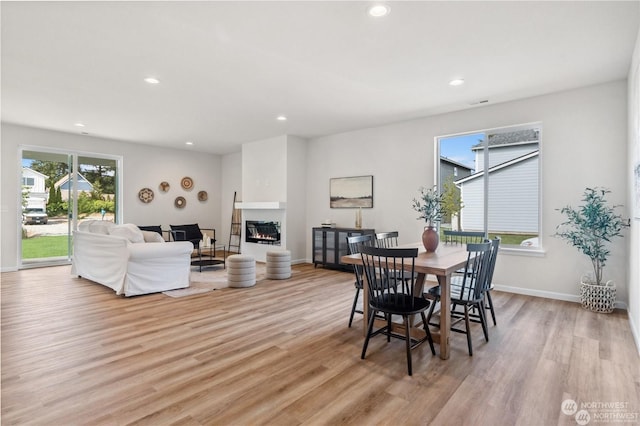 15507 65th Avenue Ct E, Puyallup, WA 98375 - dining space featuring light wood-style floors, recessed lighting, and a glass covered fireplace