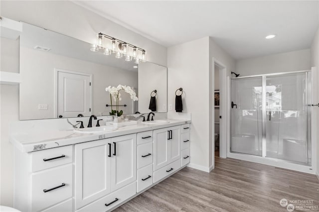 bathroom featuring vanity, hardwood / wood-style flooring, a shower with door, and toilet