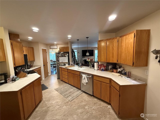 kitchen featuring kitchen peninsula, sink, pendant lighting, and appliances with stainless steel finishes