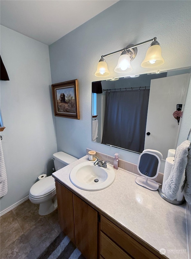 bathroom featuring vanity, toilet, and curtained shower