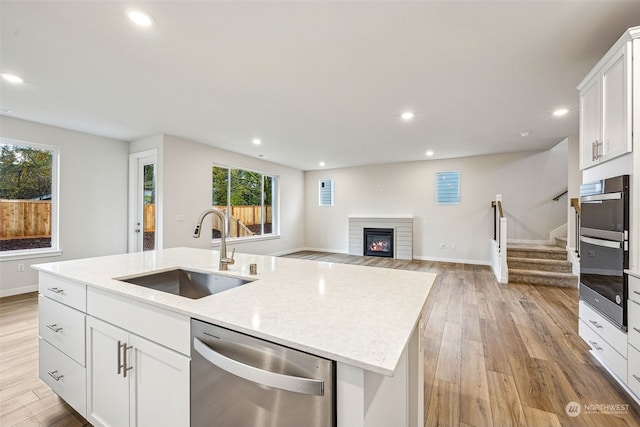 kitchen with recessed lighting, appliances with stainless steel finishes, light wood-style floors, and a sink