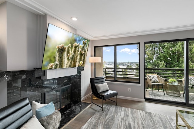 sitting room featuring a high end fireplace, ornamental molding, and hardwood / wood-style flooring