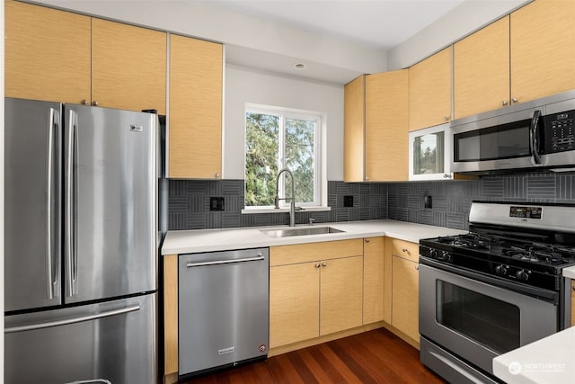 kitchen featuring backsplash, light brown cabinetry, dark hardwood / wood-style flooring, and appliances with stainless steel finishes