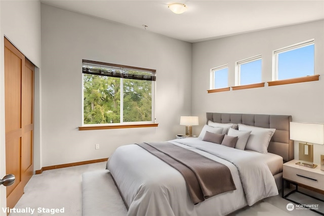 bedroom featuring a closet, lofted ceiling, light carpet, and multiple windows