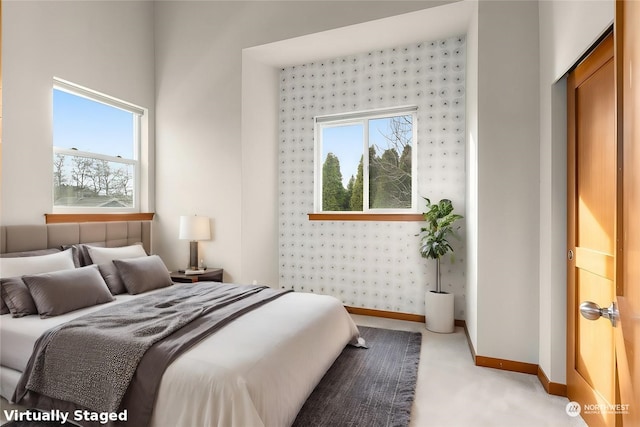 bedroom featuring multiple windows, light carpet, and a closet