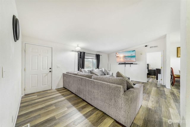 living room featuring wood-type flooring and vaulted ceiling