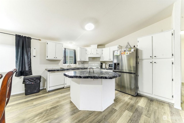 kitchen with white cabinets, light hardwood / wood-style floors, appliances with stainless steel finishes, and vaulted ceiling