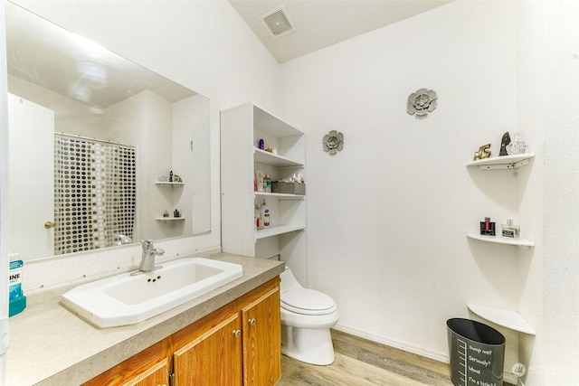 bathroom featuring hardwood / wood-style flooring, vanity, and toilet