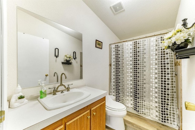 full bathroom featuring hardwood / wood-style floors, vanity, lofted ceiling, toilet, and a textured ceiling