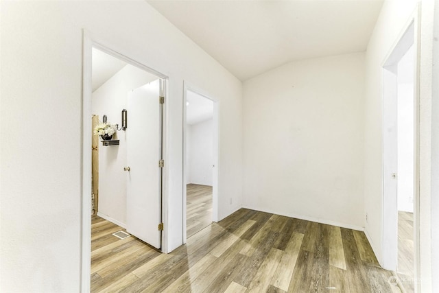 hall with hardwood / wood-style flooring and lofted ceiling