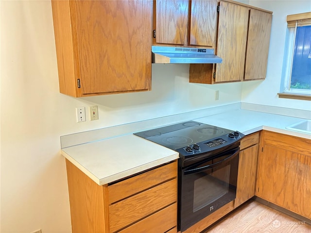 kitchen with exhaust hood, black electric range, sink, and light hardwood / wood-style floors