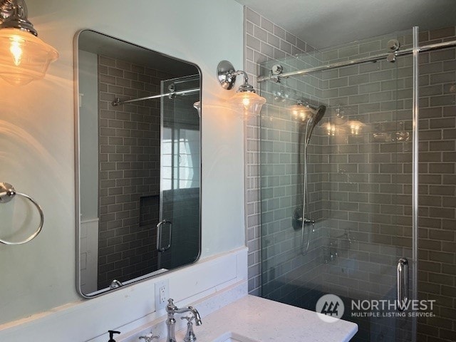 bathroom featuring vanity and a shower with shower door