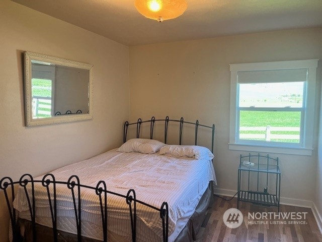 bedroom with dark wood-type flooring