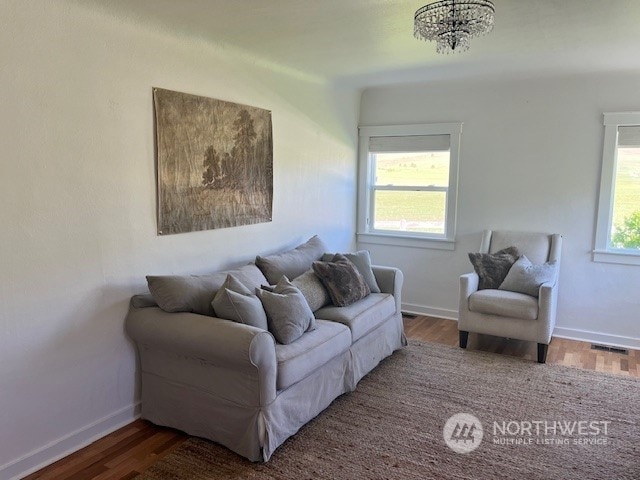 living room featuring a wealth of natural light, a chandelier, and hardwood / wood-style flooring