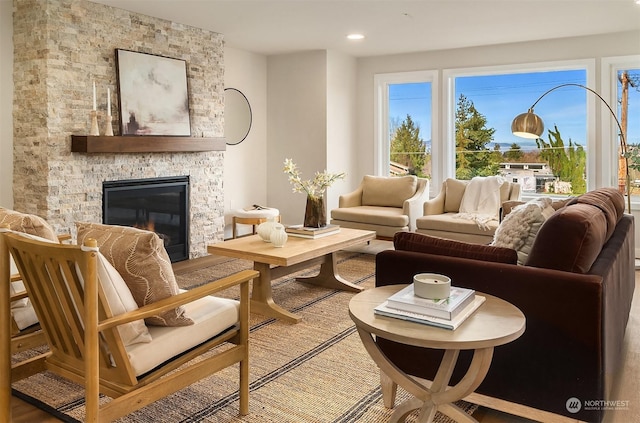 living area featuring hardwood / wood-style floors and a stone fireplace