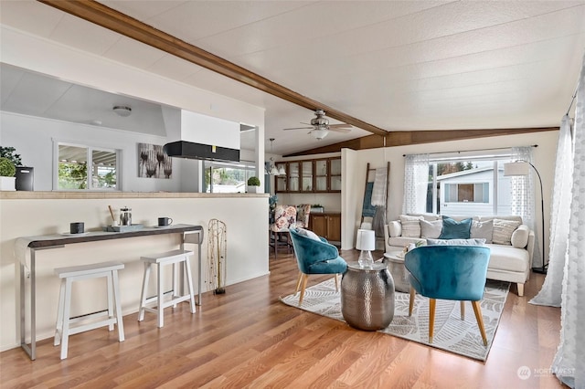 sitting room featuring vaulted ceiling with beams, ceiling fan, a healthy amount of sunlight, and hardwood / wood-style flooring