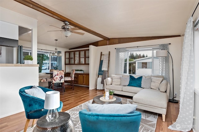 living room featuring light wood-type flooring, lofted ceiling with beams, and ceiling fan with notable chandelier