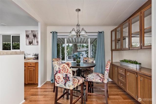 dining space featuring light hardwood / wood-style flooring, a wealth of natural light, and a notable chandelier