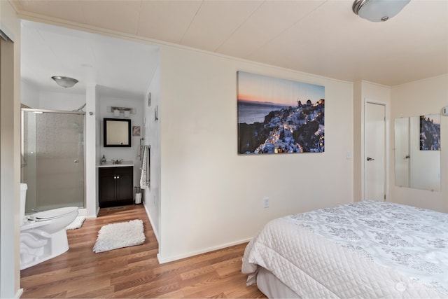 bedroom featuring hardwood / wood-style flooring, sink, and ensuite bath