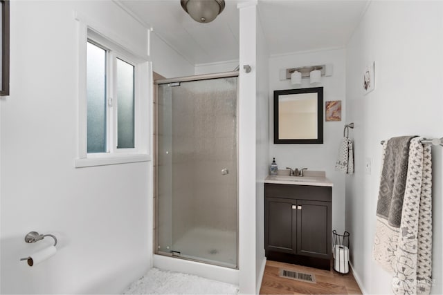 bathroom with hardwood / wood-style floors, vanity, and an enclosed shower