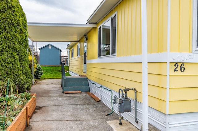 view of side of home with a patio and a shed