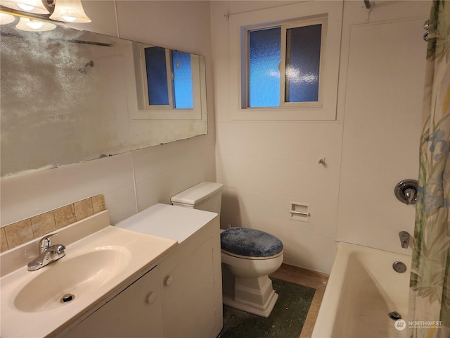 bathroom featuring vanity, toilet, and tile walls