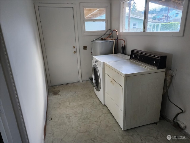 clothes washing area featuring independent washer and dryer and water heater