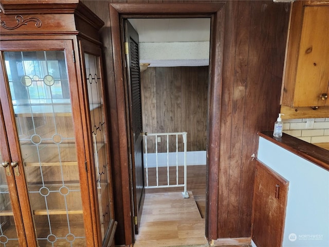 hall featuring wood walls and light wood-type flooring