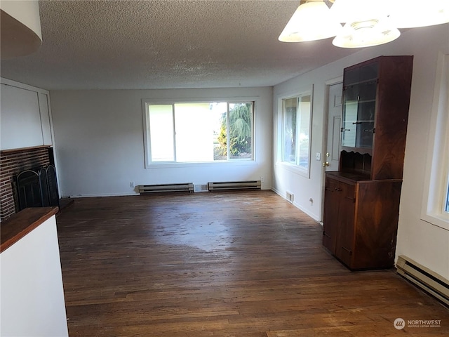 unfurnished living room with baseboard heating, dark wood-type flooring, and a textured ceiling