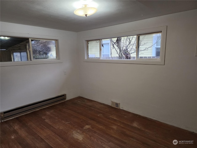 spare room with a baseboard radiator and dark hardwood / wood-style floors