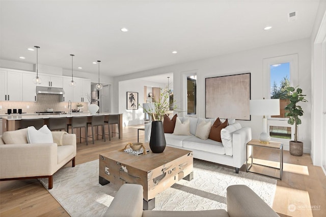 living area with light wood finished floors and recessed lighting