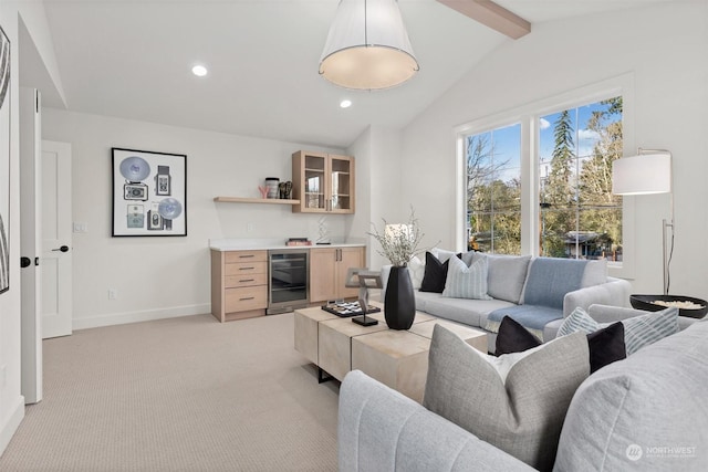 living area with lofted ceiling with beams, light colored carpet, beverage cooler, baseboards, and a dry bar