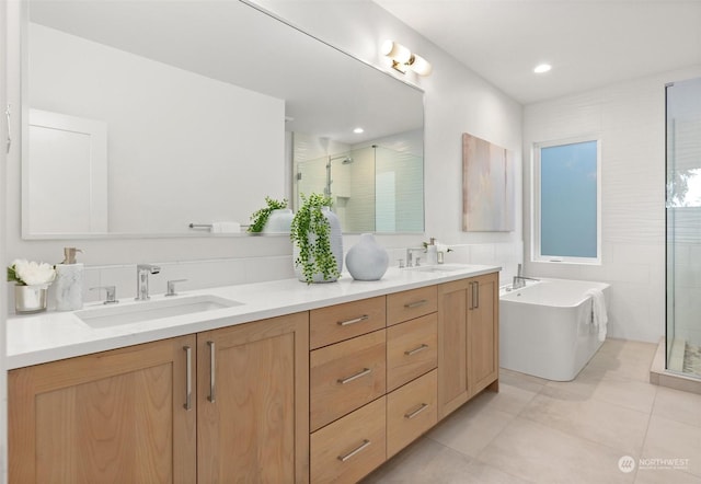 bathroom featuring double vanity, a stall shower, and a sink