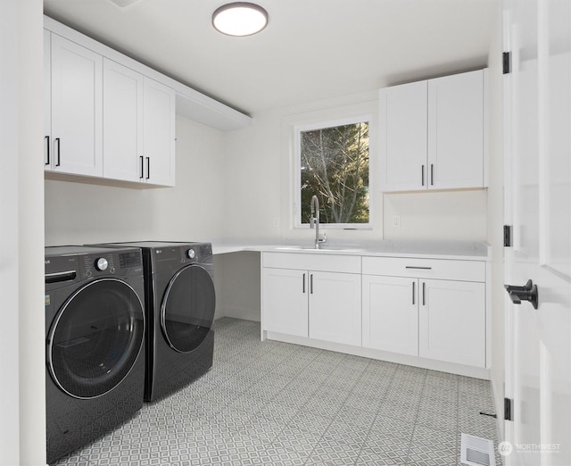 laundry area featuring a sink, visible vents, independent washer and dryer, cabinet space, and light floors