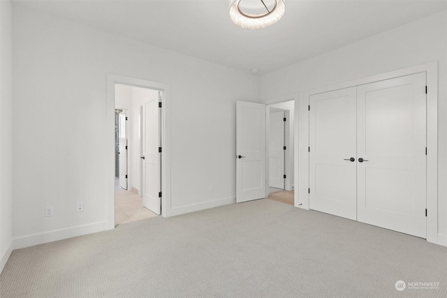 unfurnished bedroom with a closet and light colored carpet