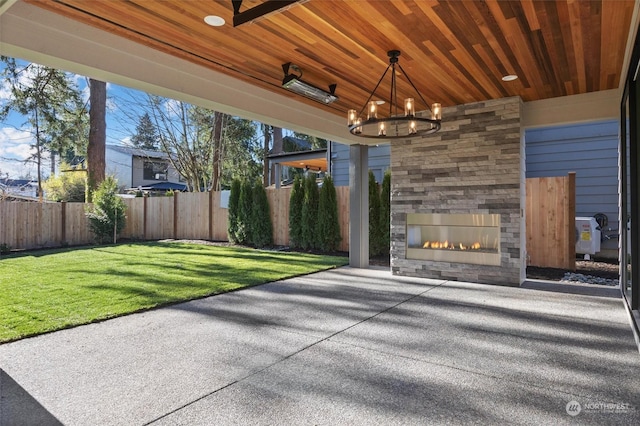 view of patio / terrace with fence and an outdoor stone fireplace