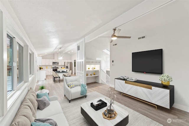 living room featuring ceiling fan, light hardwood / wood-style flooring, and lofted ceiling