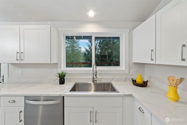 kitchen featuring white cabinets, stainless steel dishwasher, light stone countertops, and sink