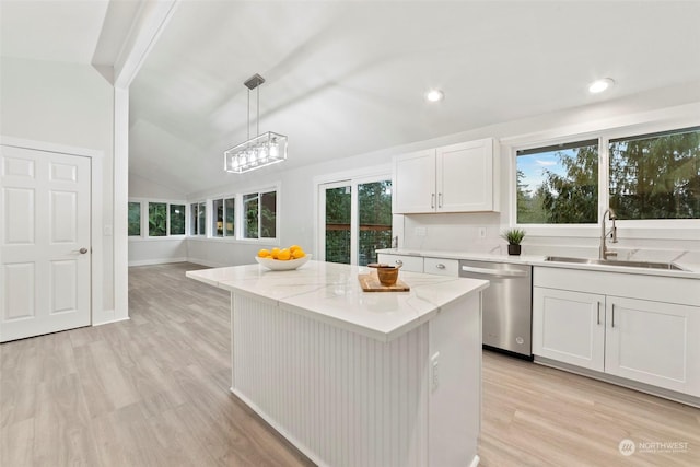 kitchen with white cabinets, vaulted ceiling, sink, decorative light fixtures, and dishwasher