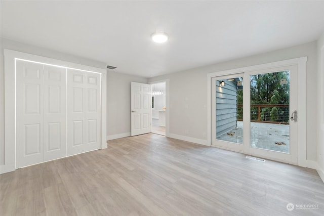 unfurnished bedroom featuring access to outside and light hardwood / wood-style flooring