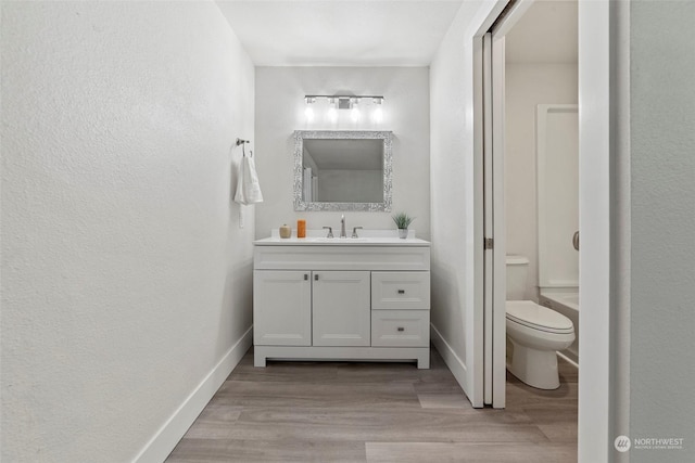 bathroom featuring vanity, hardwood / wood-style flooring, and toilet