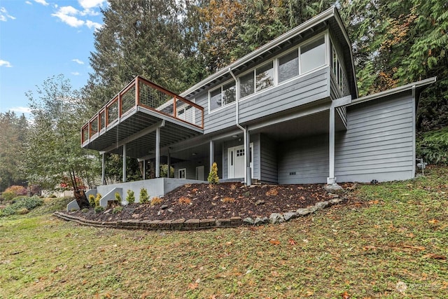 rear view of house featuring a lawn