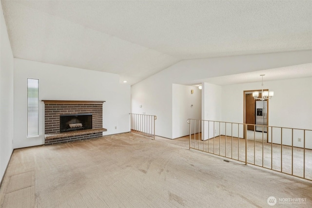 unfurnished living room with a chandelier, a brick fireplace, carpet, and lofted ceiling