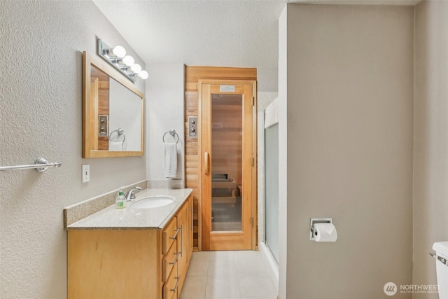 full bathroom with tile patterned flooring, a stall shower, toilet, and vanity