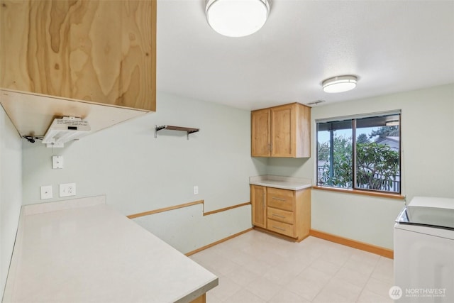 kitchen featuring visible vents, baseboards, range, and light countertops