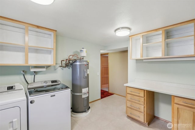 clothes washing area featuring cabinet space, water heater, light floors, and washing machine and clothes dryer