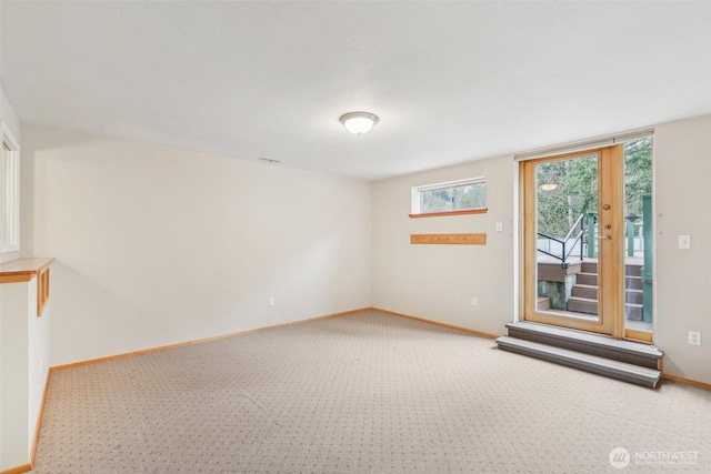 unfurnished room featuring baseboards and carpet floors